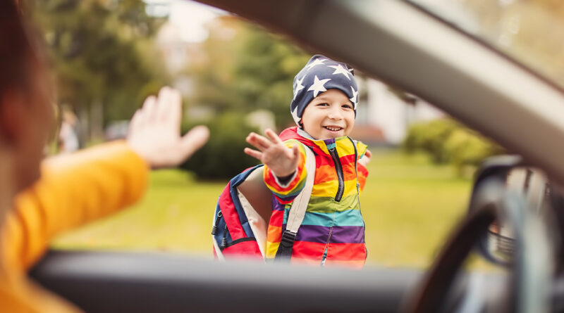 Mit Elterntaxi zur Schule: Mutter winkt ihrem Kind zum Abschied aus dem Auto zu.