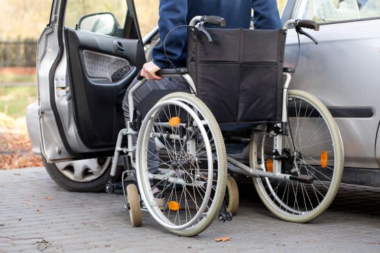 Un conductor usuario de silla de ruedas se prepara para acceder a su vehículo.